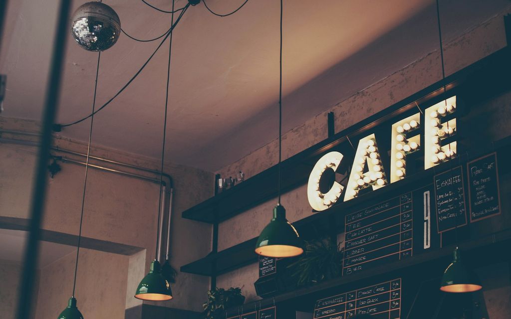 Tezgah arkasında kahve hazırlayan barista ile rahat kafe iç mekanı