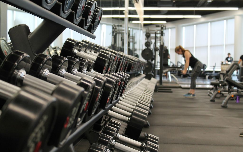 Ekipmanlarda egzersiz yapan üyeler ile modern fitness merkezi